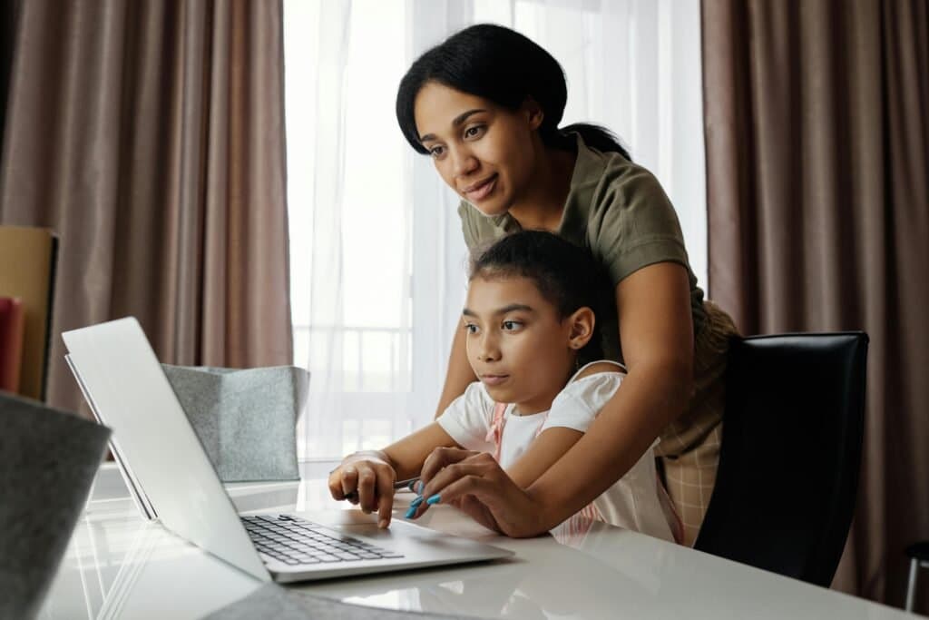 A-parent-guiding-a-child-through-a-lesson-on-a-laptop-illustrating-the-benefits-of-homeschooling-in-South-Africa